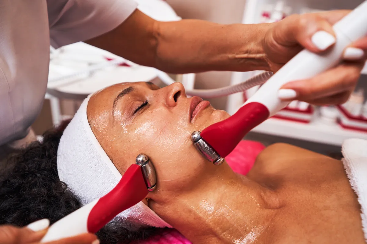 A woman getting a treatment on her face for glowing skin.
