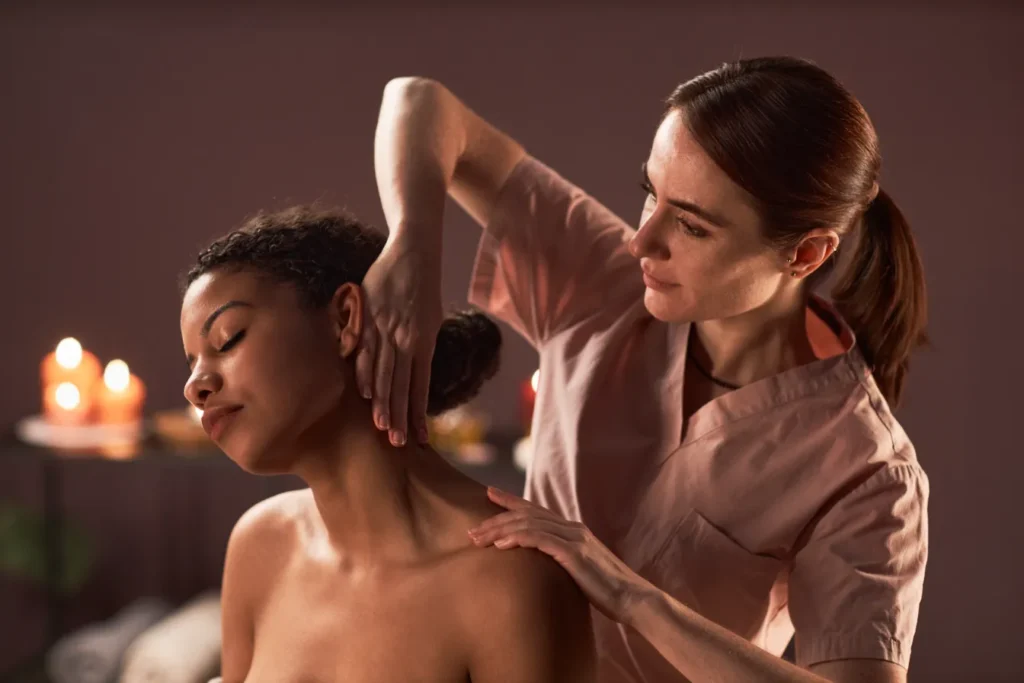 A woman being massaged in the neck part releasing the tension and ache.