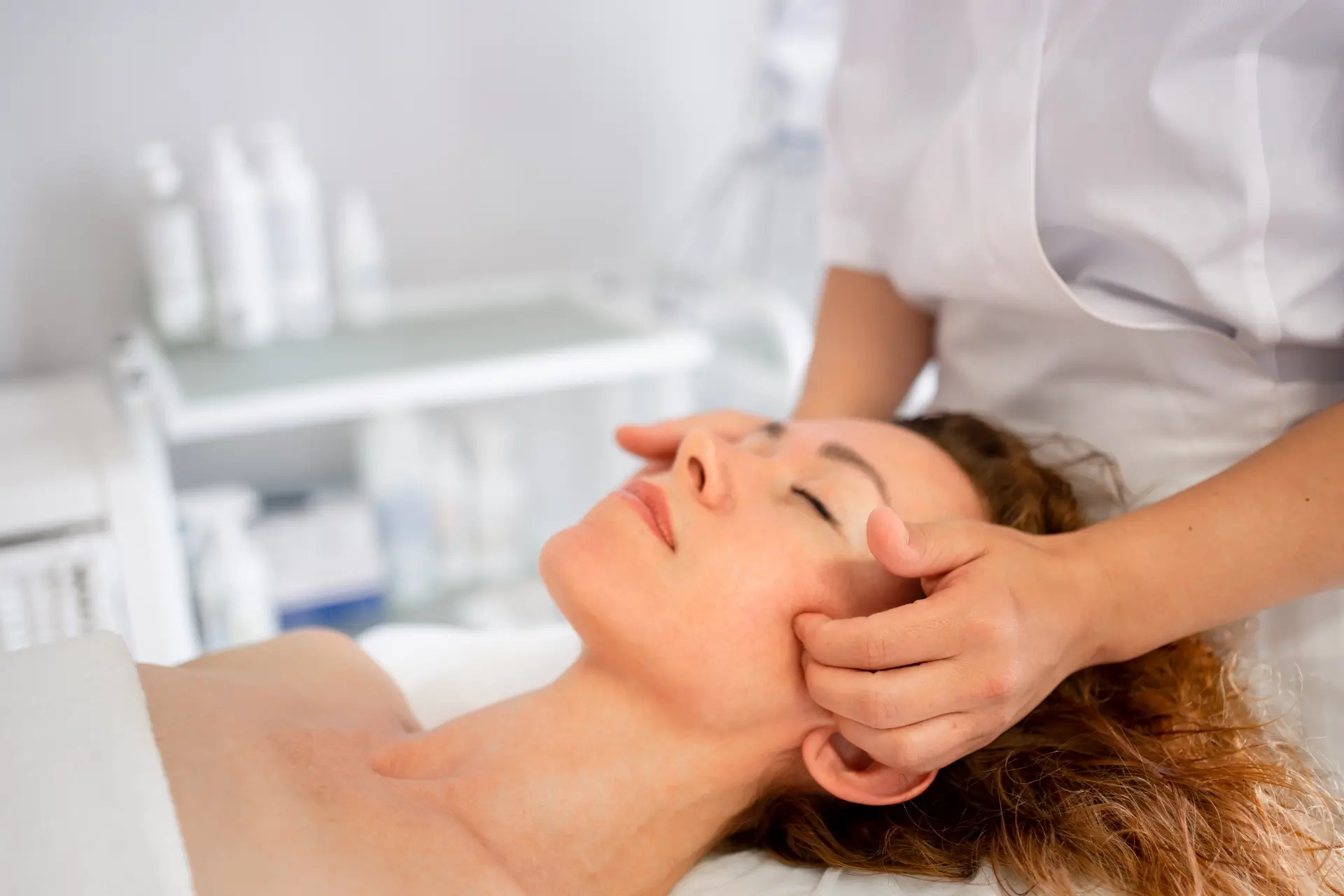 Getting massaged on the cheekbone area of the face of a woman.